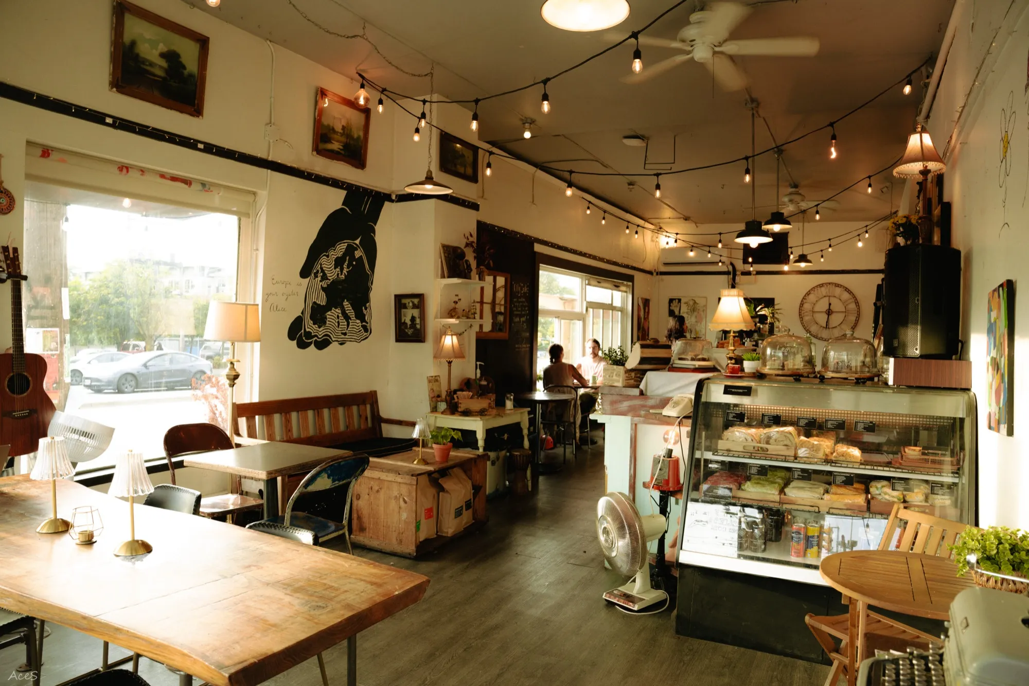 Bohemian cafe interior with string lights, guitar, vintage decor, and wall mural art